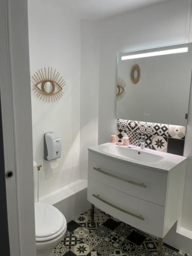 y baño con lavabo, aseo y espejo. en Hôtel de charme Equinoxe, en Le Touquet-Paris-Plage