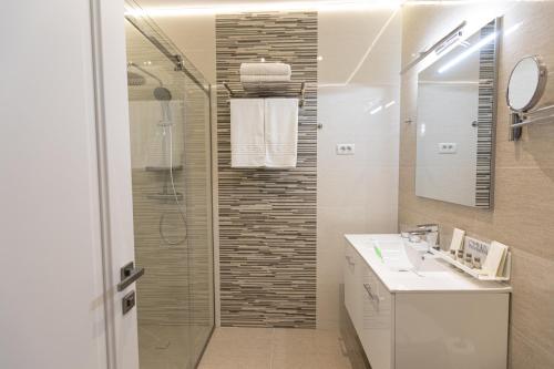 a bathroom with a shower and a sink at Omnia Apartments in Iaşi