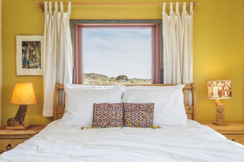 Un dormitorio con una cama blanca con una ventana. en Constellation Compound - Your Own PRIVATE 10 Acres home, en Joshua Tree