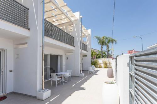 a balcony of a house with a table and chairs at Blu Marine Residence in Porto Cesareo