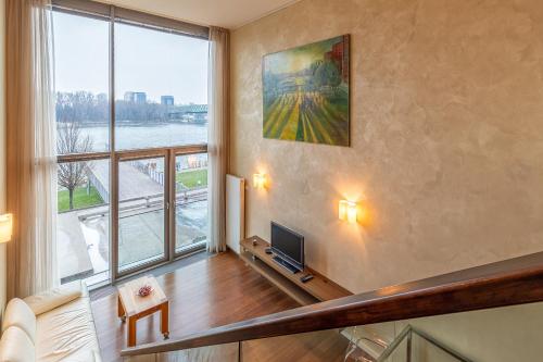 a living room with a television and a large window at Luxury with Danube river view in Petržalka