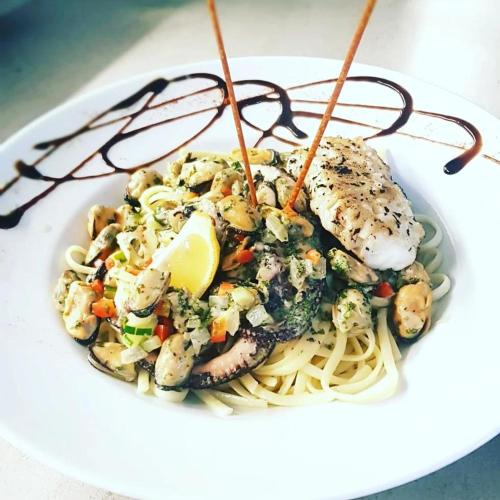 a plate of pasta with shrimp and vegetables on it at Adonis Aix en Provence in Aix-en-Provence