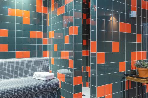 La salle de bains est revêtue de carrelage orange et bleu. dans l'établissement the niu Amity, à Potsdam