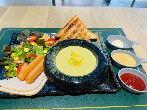 a plate of food with a sandwich and a salad at Metz Pratunam in Bangkok