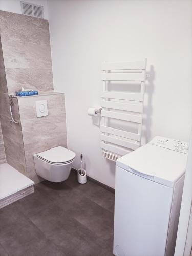 une salle de bain blanche avec des toilettes et un lavabo dans l'établissement Superbe appartement avec piscine chauffée et parking privé - La Clé Chaumoise, à La Rudelière