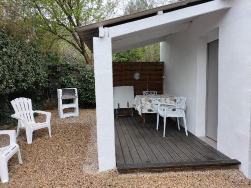 un patio avec une table et des chaises sur une terrasse dans l'établissement Le clos des cigales les lauriers roses, au Thoronet