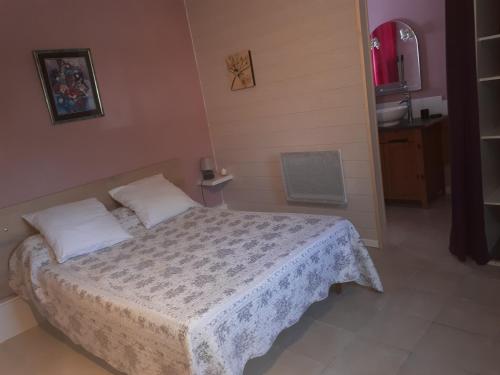 een kleine slaapkamer met een bed met een witte deken bij Le clos des cigales les lauriers roses in Le Thoronet