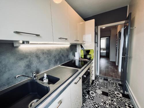 a kitchen with a sink and a counter top at Le Miramar, face mer et standing in Saint-Jean-de-Monts