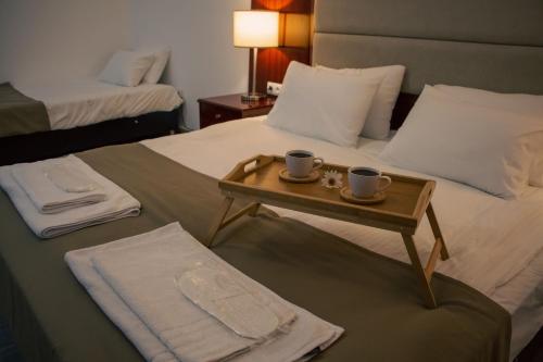 una habitación de hotel con dos tazas de café en una cama en Zhebota garden Tianeti, en Zhebota