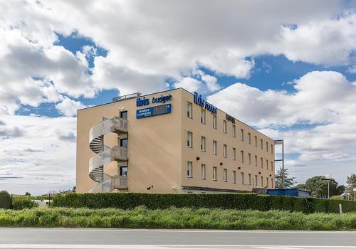 un bâtiment situé sur le côté d'une route dans l'établissement Ibis Budget Marmande, à Marmande