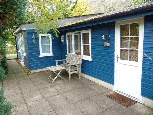 a blue house with a bench and a door at Somerset Lodge, a secret hideaway in Bath