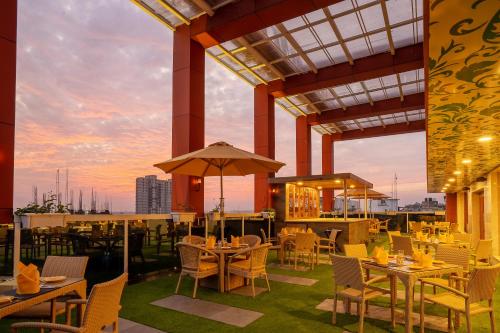 a restaurant with tables and chairs on a roof at Fortune Park Pushpanjali, Durgapur - Member ITC Hotels' Group in Durgāpur