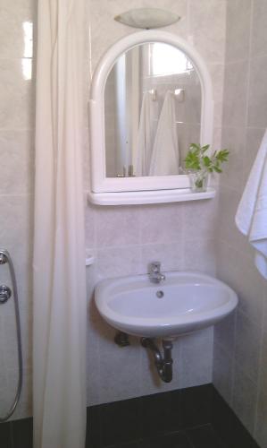 a bathroom with a white sink and a mirror at 123 Armonia Studios in Loutra Edipsou