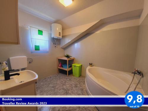 uma casa de banho com uma banheira, um lavatório e uma janela em Apartment Beverly Kožino - by the sea with free parking em Kožino