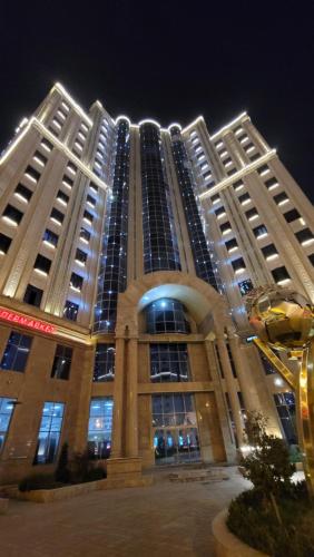 a large building is lit up at night at HOTEL AYNI in Dushanbe