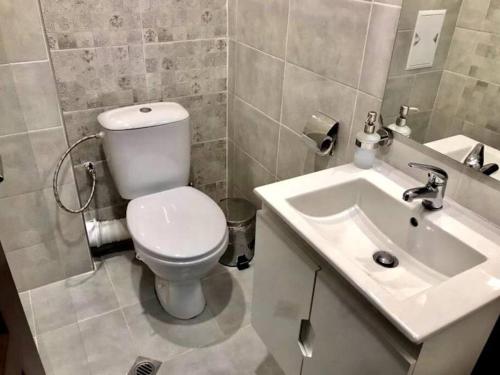 y baño con aseo blanco y lavamanos. en Comfort Luxury Apartments, en Vratsa