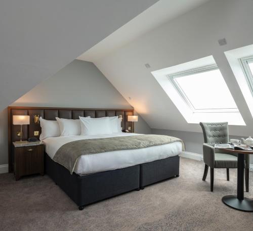 a bedroom with a large bed and a desk at Ness Walk in Inverness
