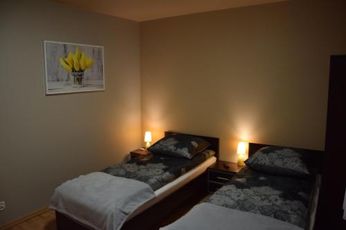 two beds in a room with two lights on at Apartament Julia 1-6 os II piętro in Kielce