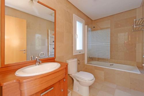 ein Badezimmer mit einem Waschbecken, einem WC und einem Spiegel in der Unterkunft Mar Menor Golf Resort - 526 in Las Casicas