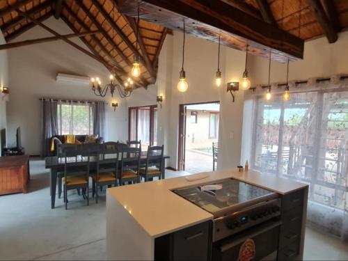 an open kitchen and dining room with a dining table at Hoedspruit Bush Stay in Hoedspruit
