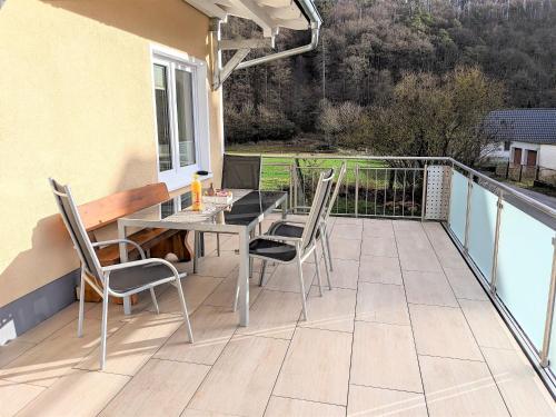 a patio with a table and chairs on a balcony at Haus Landlust in Edersee