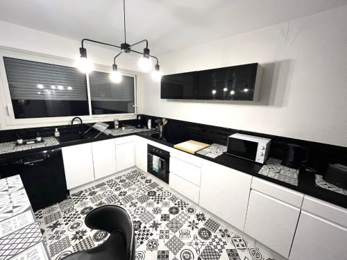 a kitchen with a black and white tile floor at La Coulée Verte - Vue dégagée in Reims