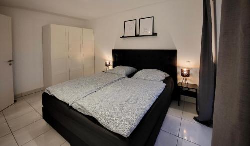 um quarto com uma cama grande e 2 candeeiros em Schöne und ruhige Wohnung direkt an der Mosel em Koblenz