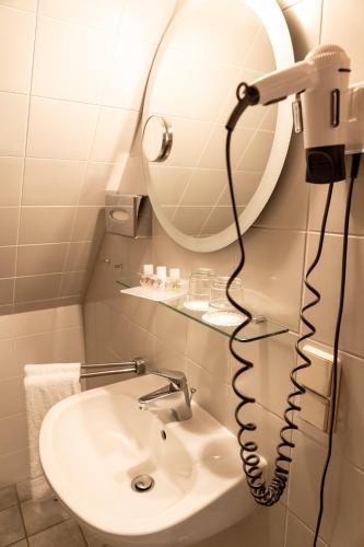 a bathroom with a mirror and a sink at Fichtelberghaus in Kurort Oberwiesenthal