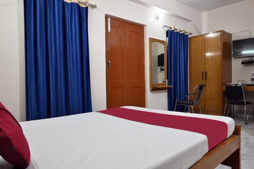 a bedroom with a bed and blue curtains at The Clovers Inn Boring Road in Patna