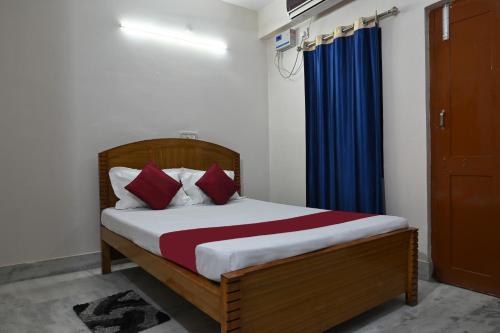 a bedroom with a bed and a blue curtain at The Clovers Inn Boring Road in Patna