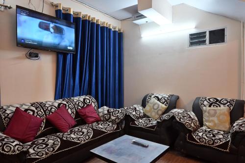a living room with a couch and a flat screen tv at The Clovers Inn Boring Road in Patna