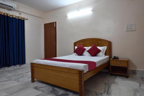 a bedroom with a large bed with red pillows at The Clovers Inn Boring Road in Patna