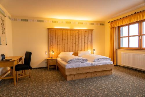 um quarto com uma cama grande e uma secretária. em Fichtelberghaus em Kurort Oberwiesenthal