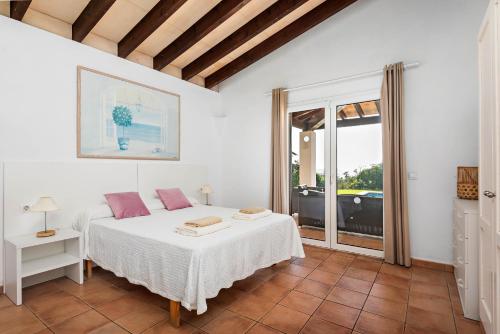 a bedroom with a white bed and a window at Villa Ribes in Binibeca