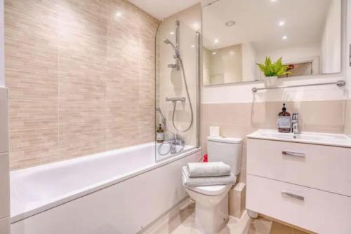 y baño con aseo, ducha y lavamanos. en Luxury app in central Welwyn Garden, sleeps 4, en Welwyn Garden City