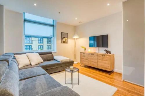 uma sala de estar com um sofá e uma televisão de ecrã plano em Luxury app in central Welwyn Garden, sleeps 4 em Welwyn Garden City