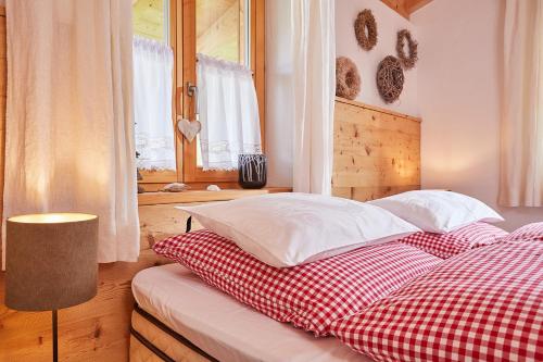 a bed with red and white pillows and a window at Ferienwohnung Dosbach in Reit