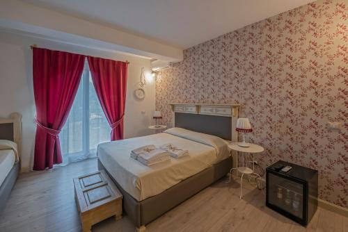 a bedroom with a large bed with red wallpaper at Etna Casa del Sole in Nicolosi
