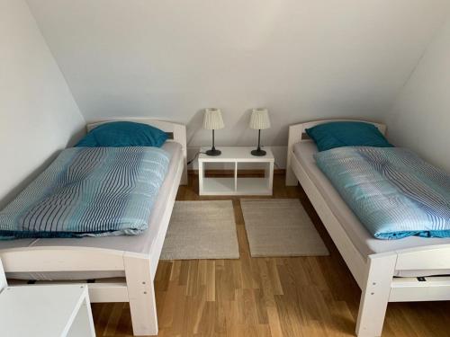 1 dormitorio con 2 camas y mesita de noche con 2 lámparas en Ferienwohnung "Nesco", en Aurich