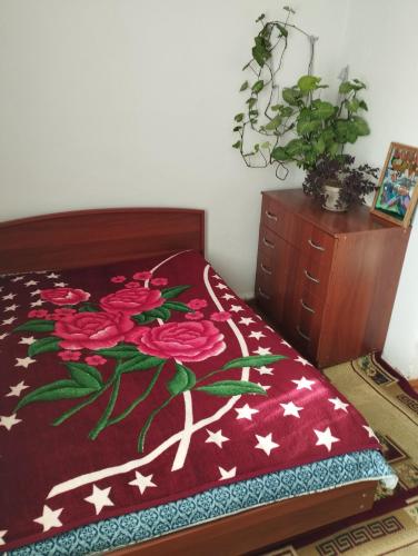 a bedroom with a bed with flowers on it at Guest house SONO adress Derbisheva 202 in Karakol