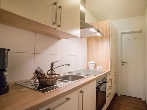 a kitchen with a sink and a basket on the counter at Ferienwohnung Lennehof in Lennestadt