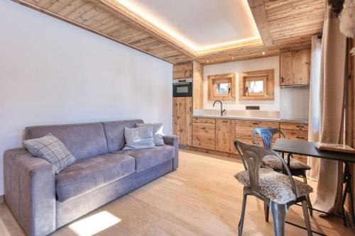 a living room with a couch and a table and chairs at Plein soleil in Saint-Gervais-les-Bains