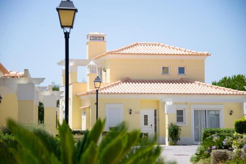 a yellow house with a street light in front of it at Castro Marim Golfe and Country Club in Castro Marim
