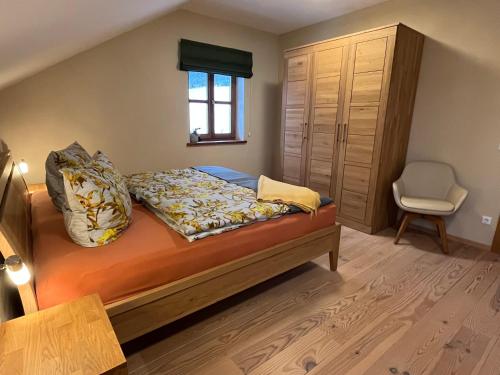 een slaapkamer met een bed, een raam en een stoel bij LICHTECK - Helle Ferien in Breitenberg