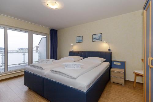 キュールングスボルンにあるYachthafenresidenz-Wohnung-9309-906のベッドルーム(大型ベッド1台、大きな窓付)