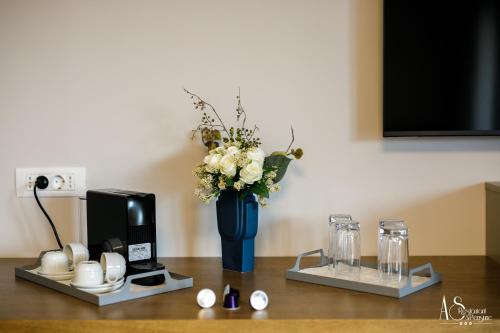 a wooden table with a blue vase with flowers in it at Pensiunea AS in Floreşti