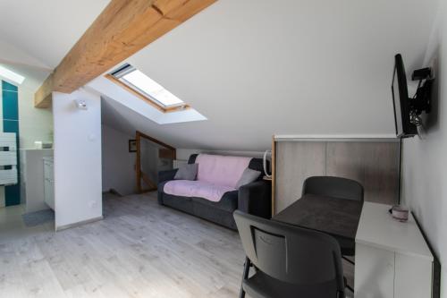 ein kleines Zimmer mit einem Bett, einem Tisch und Stühlen in der Unterkunft Le Coq Charmant petit studio en centre ville d'Embrun in Embrun