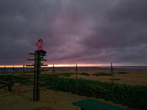 a little girl sitting on top of a tower on the beach at Dpto Bordemar 1 in Las Cruces