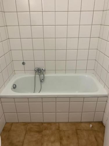 La salle de bains est pourvue d'une baignoire blanche avec un robinet. dans l'établissement Superbe studio, avec parking sur place gratuit, à Bastia