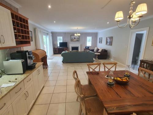 a kitchen with a wooden table and a living room at Knysna Self-catering Holiday Home in Knysna